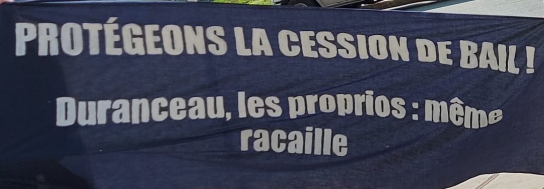 Bannière avec le slogan " protégeons la cession de bail! Duranceau, les proprios: même racaille"