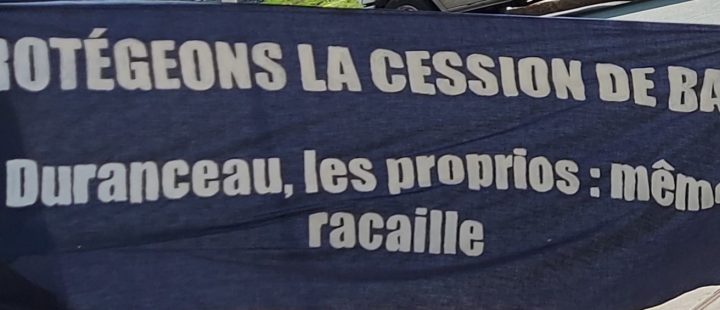 Bannière avec le slogan " protégeons la cession de bail! Duranceau, les proprios: même racaille"